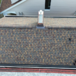 Aerial view of a pitched roof with asphalt shingles, showcasing the texture and color variations, relevant to discussions on roofing styles and their benefits for homeowners.