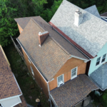 Aerial view of residential roofs showcasing shingles and gutters, relevant to identifying hail damage and maintaining structural integrity.