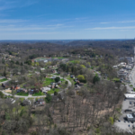 Aerial view of Reserve Township showcasing residential areas, green spaces, and nearby roads, emphasizing the importance of roof maintenance for homes in the community.