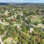 Aerial view of a residential neighborhood in Pine Township, showcasing homes surrounded by trees and greenery, emphasizing the importance of gutter maintenance for protecting properties from water damage.