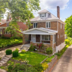 Residential home with brick exterior, front porch, and landscaped yard, highlighting proper roofing maintenance and exterior care in Peters Township.