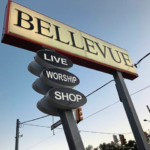 Sign for Bellevue with "LIVE," "WORSHIP," and "SHOP" directions, representing community engagement and local services.