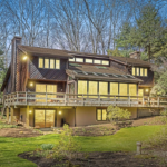 Modern residential home in Bellevue showcasing extensive windows and outdoor deck, emphasizing the importance of quality roofing and exterior maintenance.