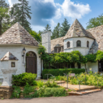 Historic home with a stone and shingle roof, surrounded by lush greenery, representing the architectural character of Knoxville, emphasizing the importance of maintaining roofs for longevity and resilience.