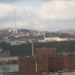 Pittsburgh skyline view featuring residential and commercial buildings, relevant to wildlife damage prevention tips for roofs in Spring Garden.
