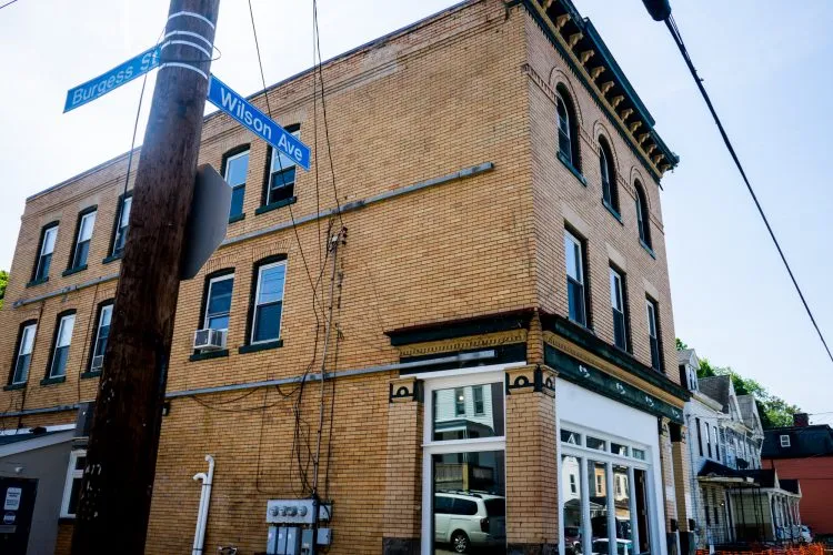 Historic building at the intersection of Burgess Street and Wilson Avenue in Pittsburgh's Perry Hilltop neighborhood, showcasing brick architecture and nearby residential structures.