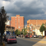 Street view of Mount Washington, Pittsburgh, featuring residential and commercial buildings, with a focus on seasonal maintenance for roofs and gutters.