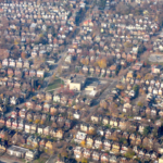 Aerial view of a residential neighborhood in Pittsburgh, showcasing tree canopy coverage over homes, relevant to roofing maintenance concerns in Garfield.