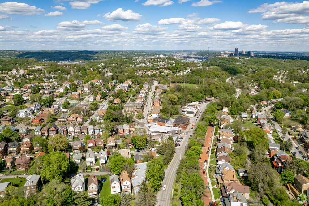 Aerial view of Crafton Heights neighborhood in Pittsburgh, showcasing residential homes, green spaces, and seasonal maintenance considerations for roofs.
