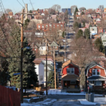 Brookline neighborhood view with residential homes, power lines, and tree-lined streets, highlighting local architecture relevant to roofing services.