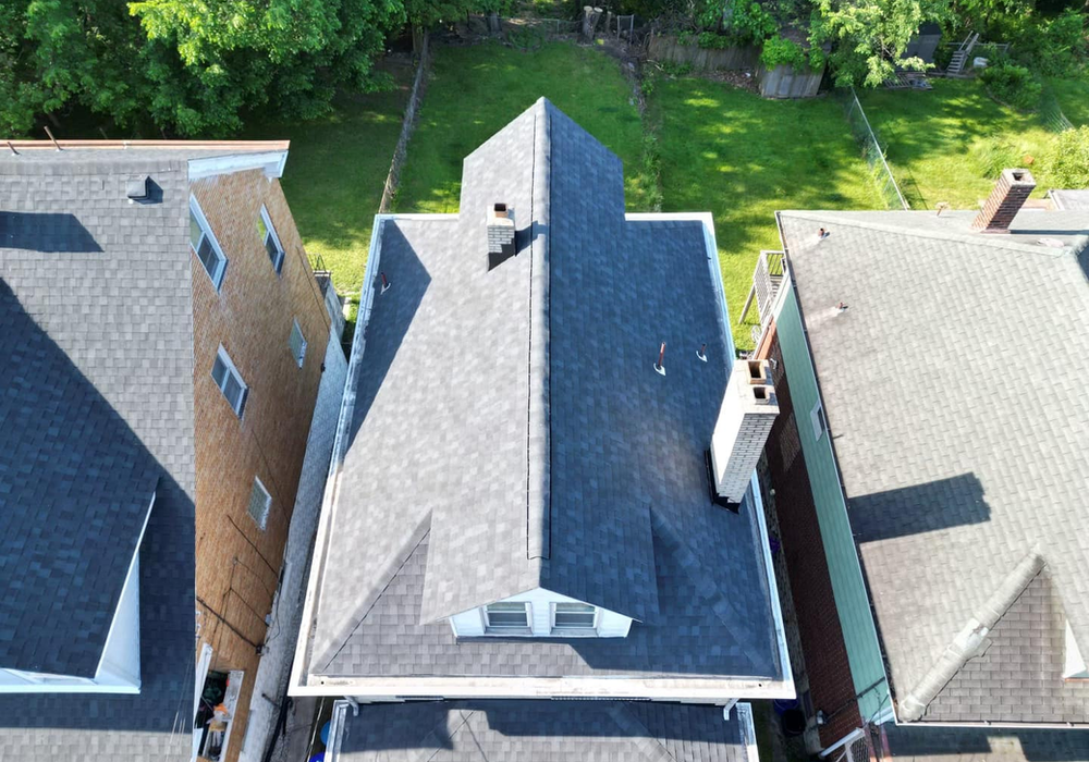 Roofing contractor inspecting shingles for common problems in Pittsburgh, featuring Malick Brothers Exteriors branding.