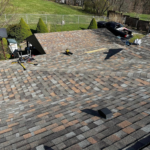 Newly installed roof showcasing durable shingles, enhancing protection against weather elements, with tools and equipment visible for roofing work.