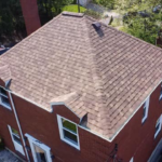 Aerial view of a residential roof with asphalt shingles, highlighting proper roof ventilation features, relevant to roof ventilation solutions offered by Malick Brothers Exteriors for Pittsburgh homes.