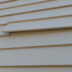 Close-up of white siding panels illustrating quality installation and maintenance, relevant to roofing and siding solutions in Pittsburgh.