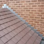 Shingle roof installation showcasing durable shingles and flashing against a brick wall, emphasizing quality roofing solutions for Pittsburgh's climate.