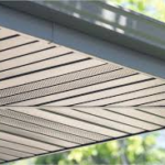 Soffit vent installation under a roof overhang, illustrating effective roof ventilation for ice dam prevention.