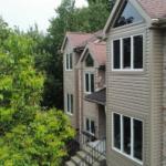 Residential building featuring EPDM roofing and large windows, surrounded by greenery, illustrating durable roofing solutions by Malick Brothers Exteriors.