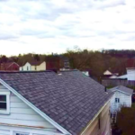 Roof featuring Atlas Pinnacle® Pristine architectural shingles in Summer Storm color, showcasing durability and aesthetic appeal against a cloudy sky.