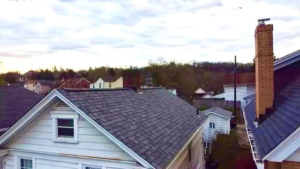 Roof view showcasing residential shingles and chimney, relevant to roof insurance claims and storm damage reporting.