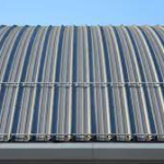 Metal roof flashing installed on a corrugated metal roof, showcasing its design and functionality in preventing water infiltration and protecting the structure.