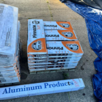 Pallet of corrugated metal roofing materials and aluminum products, showcasing packaging for durable roofing solutions.