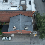Aerial view of a residential building with a sloped roof, showcasing attic ventilation features, emphasizing the importance of soffit vents for cooling attics and enhancing energy efficiency.