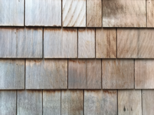Wooden roofing shingles showcasing various textures and weathering, emphasizing the importance of sourcing durable materials for roofing projects.