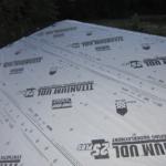 Roof underlayment installed on a sloped roof, showcasing waterproofing material and brand markings, relevant for roofing projects and material selection.