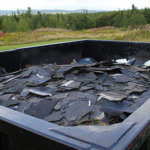 Container filled with old roof shingles, emphasizing proper disposal practices for roofing materials in Pittsburgh.