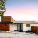 Cape Cod-style home in Pittsburgh featuring a modern design, contrasting wood and metal roofing, and a landscaped entrance, emphasizing aesthetic appeal and durability in roofing materials.