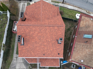 Aerial view of a residential roof with asphalt shingles, showcasing sustainable roofing practices and potential for material recycling in Pittsburgh.