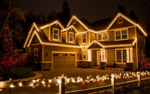 Beautifully decorated house with festive lighting, showcasing a warm exterior in a nighttime setting, emphasizing holiday cheer and seasonal maintenance considerations for roofing.
