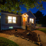 Split-level home exterior at night, featuring illuminated entryway, landscaped yard, and steps leading to the front door, highlighting aesthetic appeal and welcoming atmosphere for homeowners in Pittsburgh.