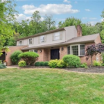 Two-story brick home with landscaped front yard, showcasing modern siding and roofing options suitable for Pittsburgh's Friendship neighborhood.