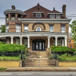 Historic residential building with modern architectural elements, featuring a grand entrance, decorative columns, and lush landscaping, reflecting the blend of style and sustainability in Robinson Township.