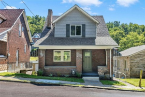 Modern home exterior with a combination of brick and fiber cement siding, showcasing energy-efficient windows and a well-maintained landscape, illustrating ideal siding choices for durability and low maintenance.
