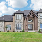 Elegant home exterior showcasing modern stone and brick siding, featuring large windows and a prominent entrance, reflecting the potential for enhanced curb appeal in McCandless Township.