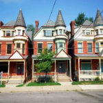 Row of Victorian-style homes in Point Breeze, showcasing unique architectural features and varied roofing styles, emphasizing the importance of durable roofing materials in local weather conditions.