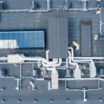Roofing system overview with ventilation pipes and HVAC units, illustrating commercial roofing solutions for durability against Pittsburgh's weather conditions.