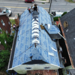 Roofing crew working on a rubber roof installation, showcasing maintenance techniques and materials for enhancing roof longevity.