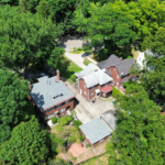 Aerial view of Pittsburgh homes surrounded by greenery, showcasing various siding materials and roofing styles.