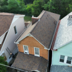Aerial view of residential roofs in Pittsburgh, showcasing various roofing materials and styles, relevant to selecting a roofing contractor for home repairs and replacements.