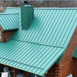 Metal roofing installation on a residential log cabin, showcasing a green metal roof with a chimney, emphasizing durability and energy efficiency for Pittsburgh homes.