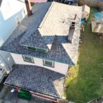 Aerial view of a residential home in Pittsburgh showcasing a recently installed asphalt shingle roof, highlighting the importance of quality roofing materials for long-term protection against weather elements.