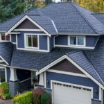 Aerial view of a modern residential home with a dark shingle roof, showcasing architectural details and landscaping, relevant to roofing maintenance and inspection services in Pittsburgh.