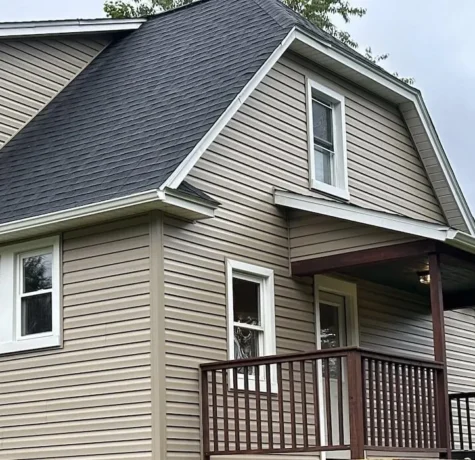 Residential property with newly installed gray roofing and beige siding, showcasing a well-maintained exterior in Pittsburgh, relevant to roofing and siding services offered by Malick Brothers Exteriors.