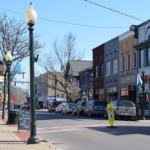 Sewickley downtown street scene with storefronts, parked cars, and a lamp post, reflecting the community atmosphere in the North Hills of Pittsburgh.