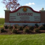 Cranberry Township welcome sign featuring landscaped flowers and grass, highlighting the community in Pennsylvania, relevant to local roofing services and homeowner needs.