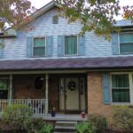 Pittsburgh home with blue shutters and a welcoming porch, showcasing quality residential roofing and siding by Malick Brothers Exteriors.