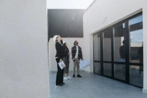 Group of individuals inspecting a roof, discussing roofing permits and inspections in a residential setting, emphasizing compliance with Pennsylvania construction regulations.